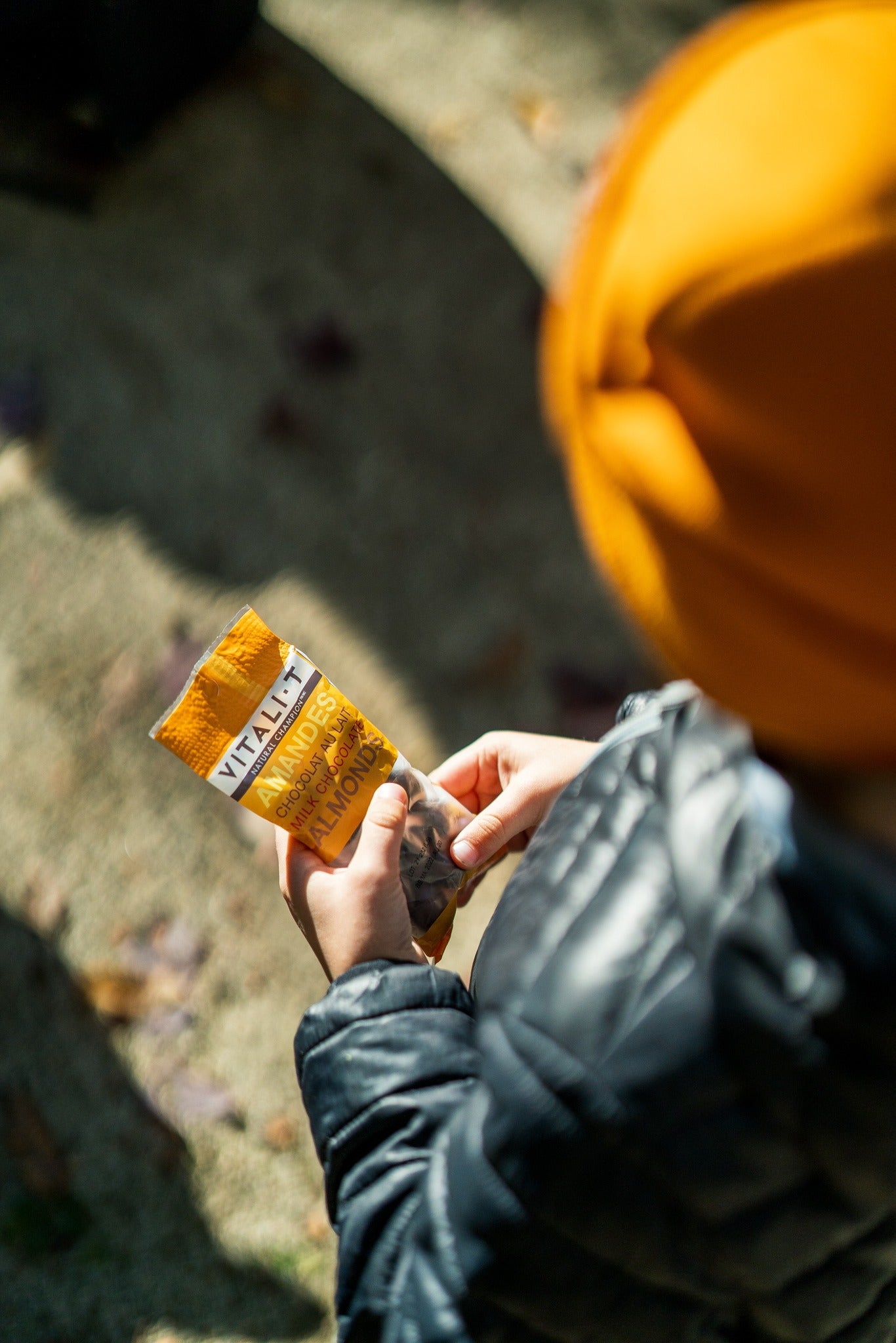 Enfant qui tient une collation mélanges de noix amandes et chocolat Vitali-T. 