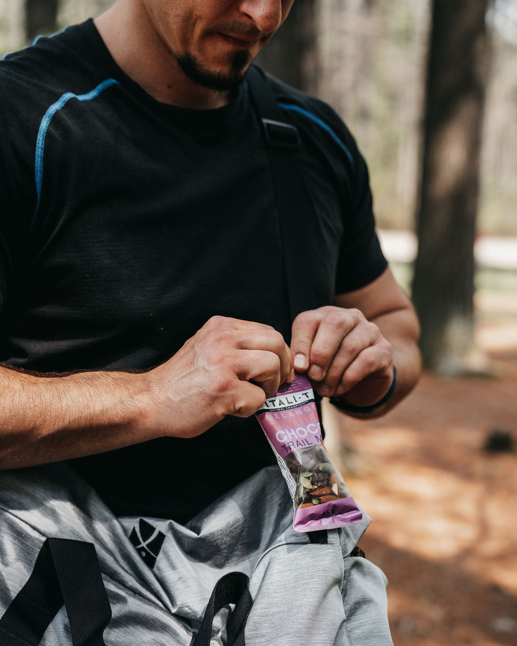 Homme sportif en train de manger collations mélanges de noix choco sentier Vitali-T. 