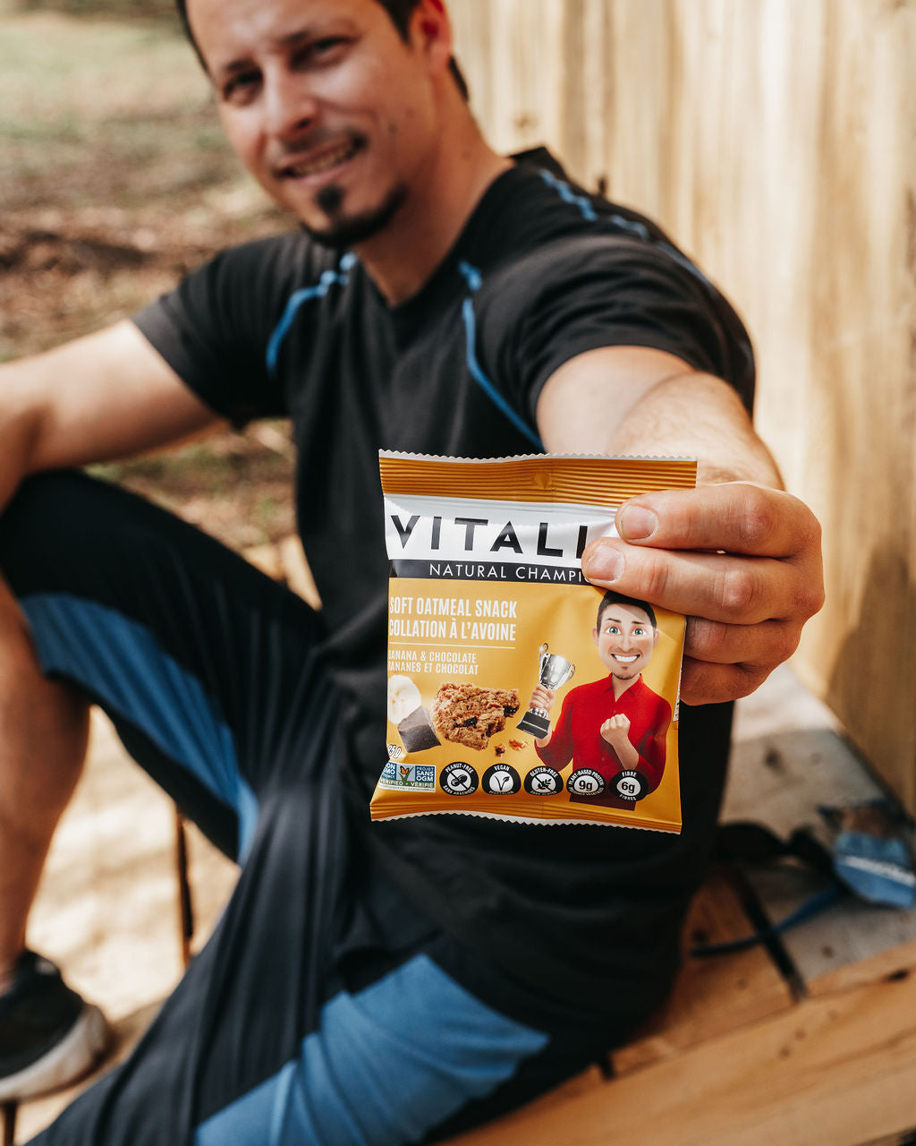 Homme sportif qui tient une collation Vitali-T dans la main